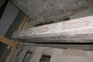 Zachovalý trám s původní malbou a vyřezanými kazetami.